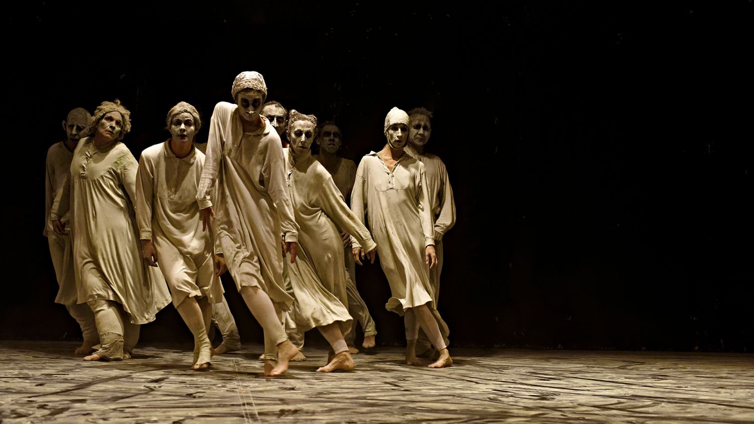 Photo de danseurs habillés avec des vêtements amples et clairs avec le visage maquillé blanc
